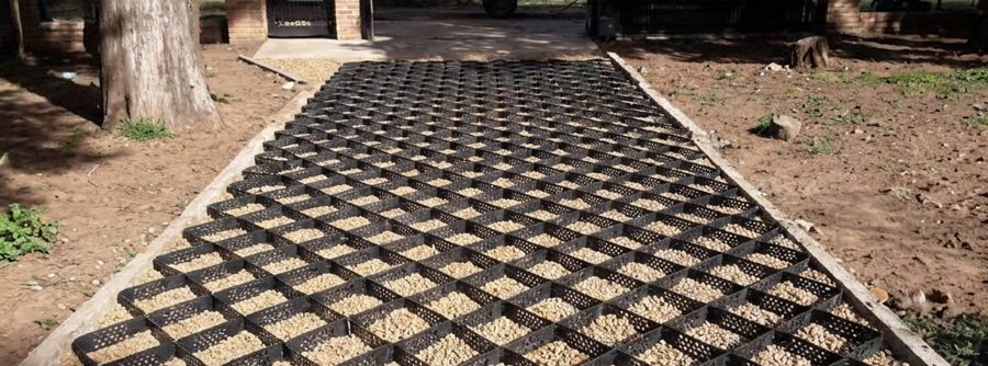 Camino de acceso terminado, geocelda rellena de gravilla bajo el vehículo